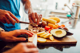 a person cutting vegetables on a cutting board